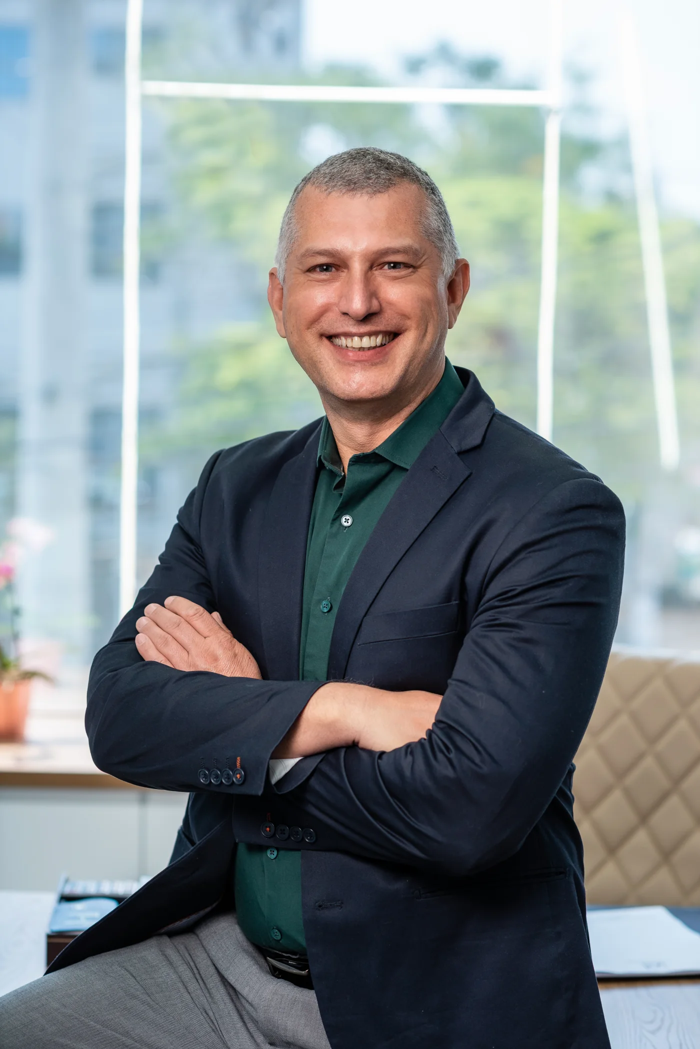 Dr. Elzo sorrindo, de blazer e braços cruzados