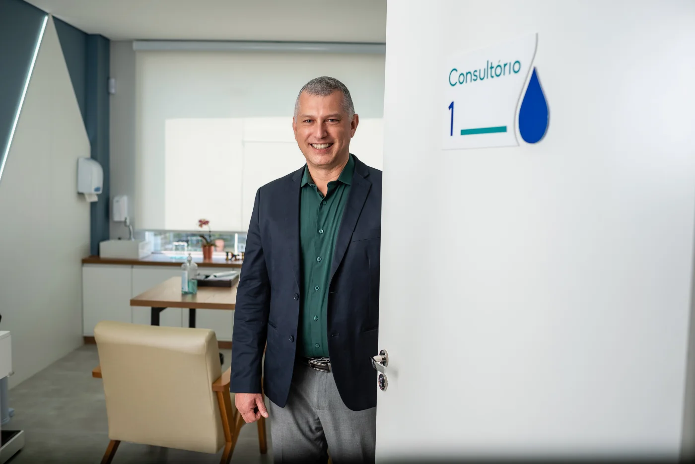Dr. Elzo em pé na sala de atendimento