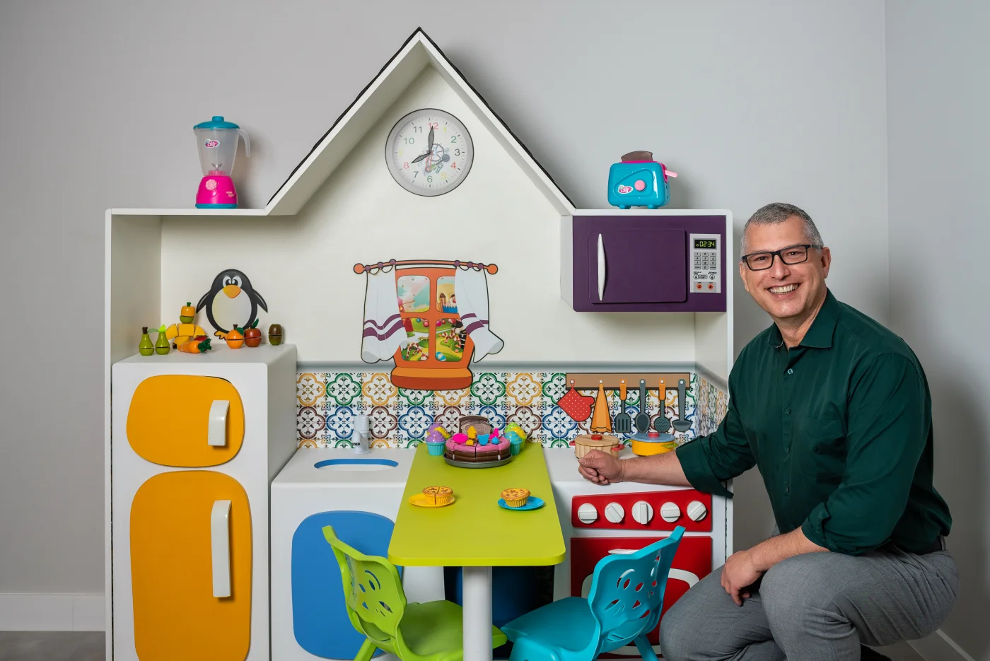Dr. Elzo sentado junto ao espaço infantil da clínica